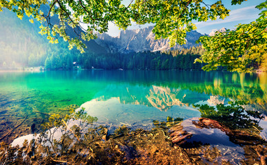 Obrazy na Szkle  Imponujący poranny widok na jezioro Fusine. Fantastyczny letni wschód słońca w Alpach Julijskich ze szczytem Mangart na tle, Prowincja Udine, Włochy, Europa. Podróżowanie koncepcja tło.