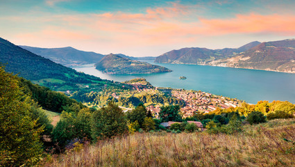 Aerial summer view of Iseo lake. Colorful morning cityscape of Marone town with Monte Isola island, Province of Brescia, Italy, Europe. Traveling concept background.