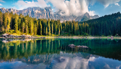 Attractive summer view of Carezza (Karersee) lake. Amazing morning scene of Dolomiti Alps, Province of Bolzano, South Tyrol, Italy, Europe. Beauty of nature concept background.