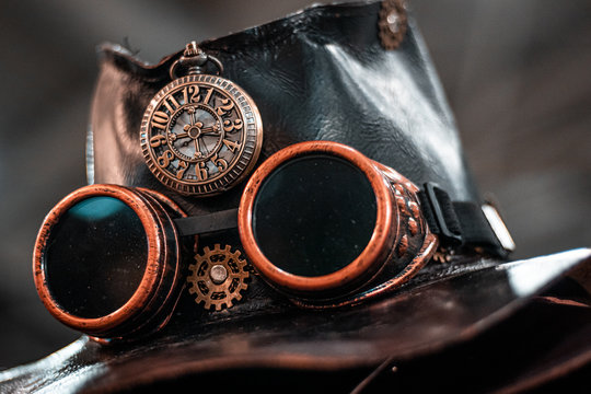 Steampunk goggles on dark leather hat. Close up shot, high quality costume design, ideas for halloween. Adventure time concept. Fantasy movie atmosphere. 
