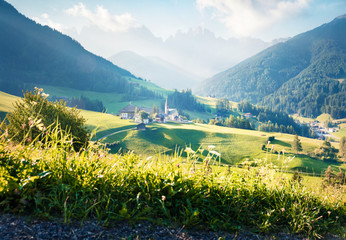 High key style view of Santa Maddalena or Santa Maddalena village. Picturesque summer scene of Funes valley. Picturesque landscape of National park Puez Odle or Geisler, Italy, Europe.