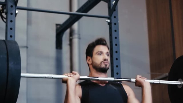 Handsome sportsman weightlifting barbell in gym
