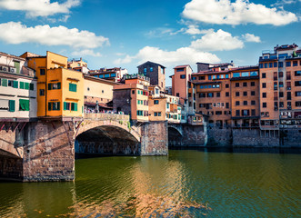 Fototapeta na wymiar Picturesque medieval arched river bridge with Roman origins - Ponte Vecchio over Arno river. Colorful spring morning view of Florence, Italy, Europe. Traveling concept background.