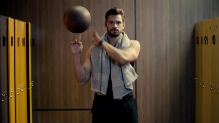 handsome sportsman spinning basketball in finger  - Powered by Adobe