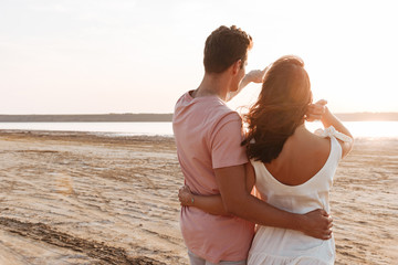 Beautiful young couple wearing summer clothing standing at the beach