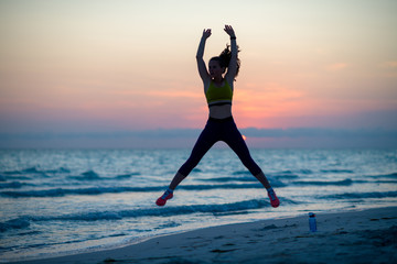 fitness woman on ocean coast in evening workout