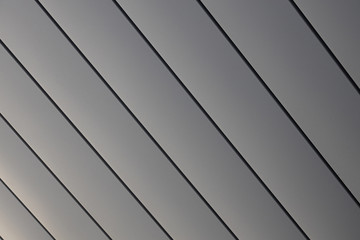 Close-up of smooth shiny grey siding wall of building