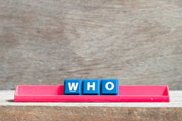 Tile letter on red rack in word who on wood background