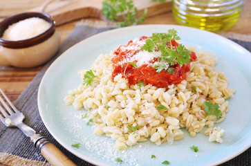 Pearl barley with tomato sauce and grated parmesan cheese