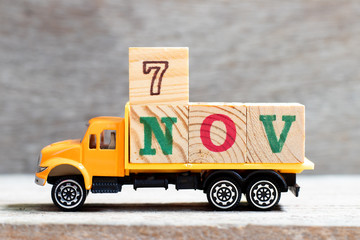 Truck hold letter block in word 7nov on wood background (Concept for date 7 month November)
