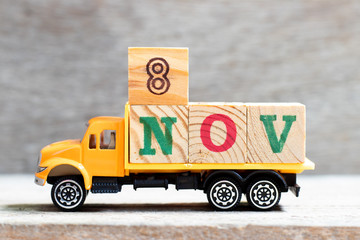 Truck hold letter block in word 8nov on wood background (Concept for date 8 month November)