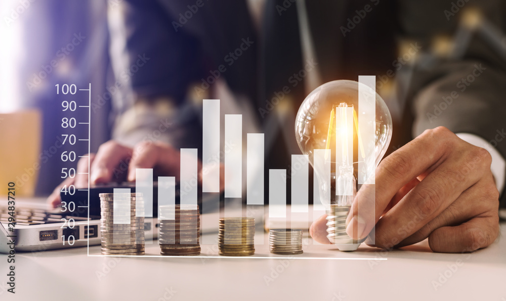 Poster business hand holding lightbulb with using laptop computer and money stack in office. idea saving en