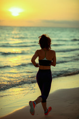 healthy sports woman on ocean shore in evening running