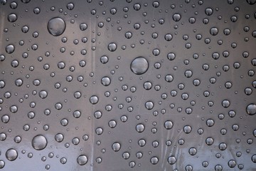 Perfectly shaped water drops on transparent plastic 
