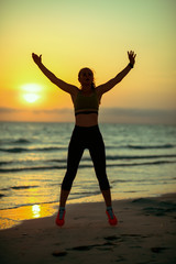Fototapeta premium young sports woman on seashore in evening training