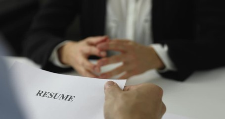 hiring manager interviews a woman in a job interview discussing resume