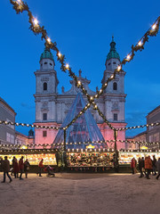 Fototapeta premium Salzburg, Austria. Christmas market at the Domplatz (Cathedral Square) in front of Salzburg Cathedral in twilight.