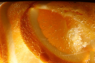 orange cut into slices in a glass of sparkling water.