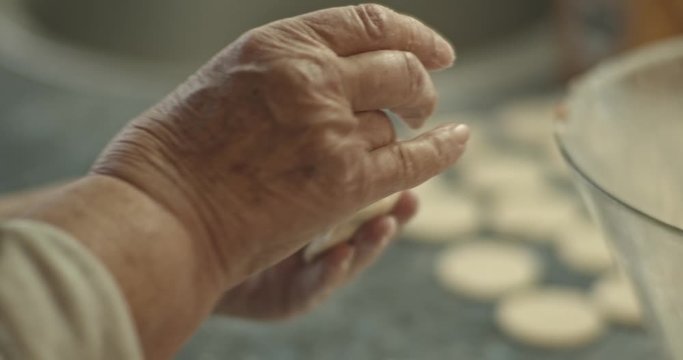Grandmother makes a traditional Russian dish of dumplings, pelmeni, close-up