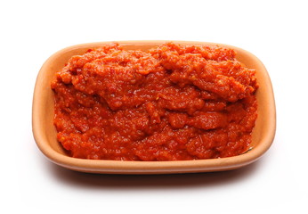 Ajvar, red paprika, pepper and eggplant dish in clay pot, bowl isolated on white background