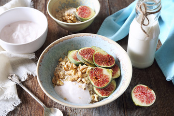 Healthy breakfast: oatmeal, yogurt, ripe figs, walnuts and milk