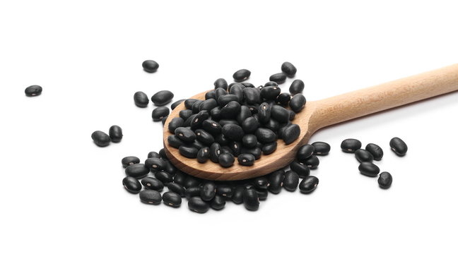 Black beans with wooden spoon isolated on white background
