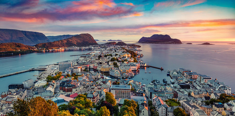 From the bird's eye view of Alesund port town on the west coast of Norway, at the entrance to the Geirangerfjord. Colorful summer sunset at the Nord port. Traveling concept background.