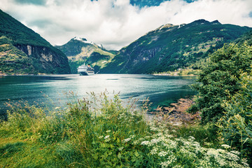 Fototapeta na wymiar Gloomy summer scene of Geiranger port, western Norway. Colorful view of Sunnylvsfjorden fjord. Traveling concept background. Artistic style post processed photo.