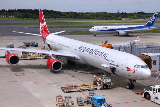 TOKYO - MAY 12: Passengers board Virgin Atlantic Airbus A340 on May 12, 2012 at Narita International Airport, Tokyo. Narita was 8th busiest airport in Asia in 2008 with 32.7m passengers.