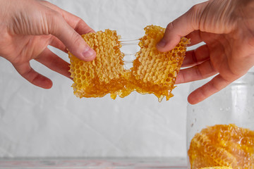 Honeycombs in the hands of which flow out sticky sweet honey - 294844487