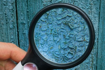 Fototapeta na wymiar black magnifier enlarges the blue wall in cracked paint