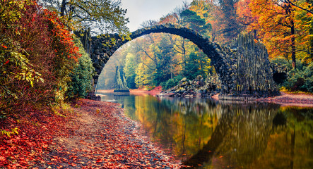 Panoramische Morgenszene von Azaleen- und Rhododendronpark Kromlau, Deutschland, Europa. Malerisches Herbstpanorama der Rakotzbrücke (Rakotzbrücke, Teufelsbrücke). Hintergrund des reisenden Konzepts.
