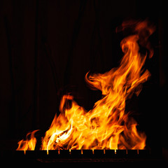 Fire. Bright burning fire at night. A fire in the grill, fireplace and hearth.