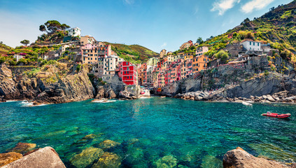 First city of the Cique Terre sequence of hill cities - Riomaggiore. Sunny morning view of Liguria, Italy, Europe. Splendid spring seascape of Mediterranean sea. Traveling concept background.