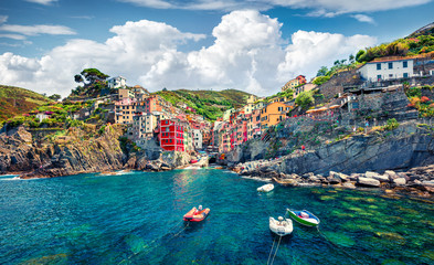 Sunny summer view of  Riomaggiore - Cique Terre sequence of hill cities. Wonderful morning view of Liguria, Italy, Europe. Splendid spring seascape of Mediterranean sea. Traveling concept background.