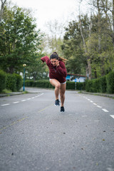 Fast powerful young woman sprinting. Running training on urban suburbs road.