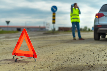 Vehicle breakdown and warning triangle on the road