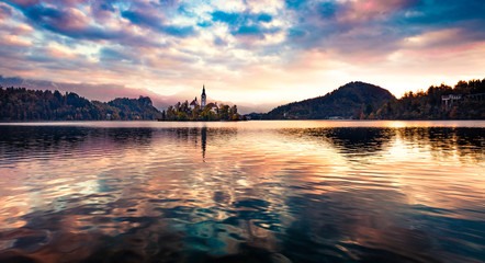 Panoramic morning view of Pilgrimage Church of the Assumption of Maria. Breathtaking autumn scene of Bled lake, Julian Alps, Slovenia, Europe. Traveling concept background.