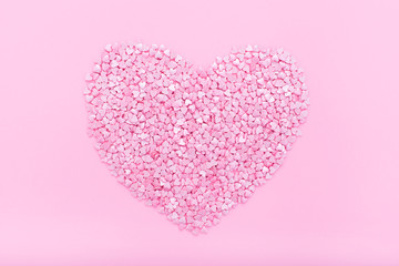 Pink background. Pink hearts on a pink background. Hearts sprinkles. Flat lay style. Top view. Sweet background. Confetti.