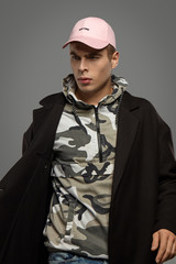 Medium close-up shot of a short-haired European man dressed in a dazzle hooded top, a black jacket...