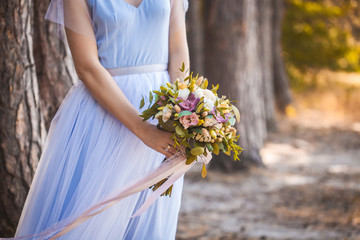 bridal bouquet of roses in the the bride's hands. wedding