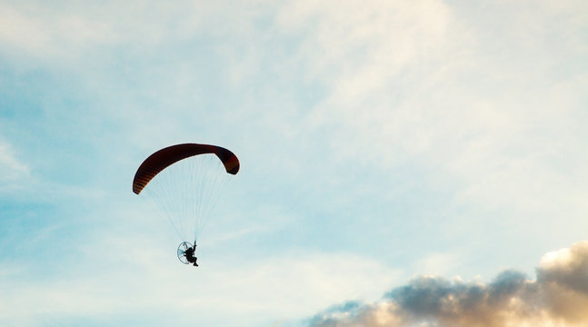 silhouette of skydiver with parachute - live your dream, freedom and adrenaline concept