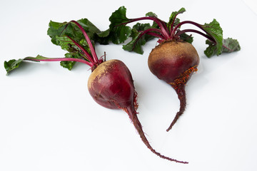 Two Fresh raw beets with tops close-up on a white background