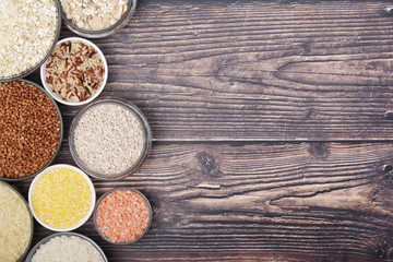 A set of bowls filled with different seeds: buckwheat, rise, corn and oatmeal	