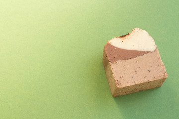 Natural handmade soap with cocoa and cinnamon on green  background and copy space