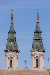 Fototapeta na wymiar Two spiers of the clock towers and a cross of the old Orthodox E