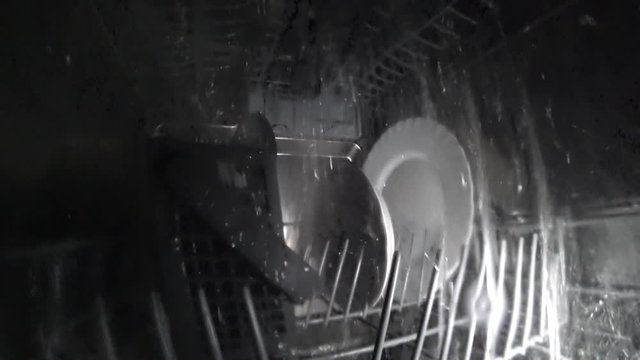 Inside the dishwasher, water jets fill the entire space, washing dishes
