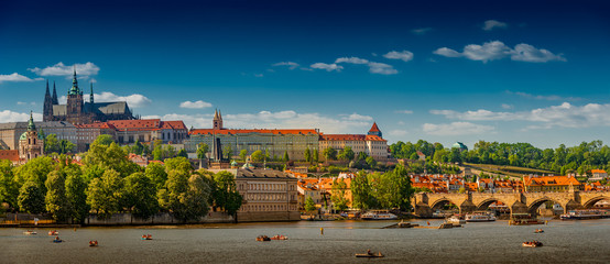 Fototapeta premium Panoramic view of magnificent Saint Vitus Cathedral and Charles Bridge in Prague during early sunset, Czech Republic