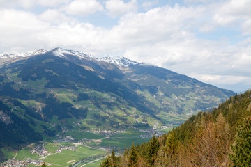 Fototapeta premium Majestic landscape of summer mountains. A view of the misty slopes of the mountains in the distance. Morning misty coniferous forest hills in fog and rays of sunlight. Travel background.