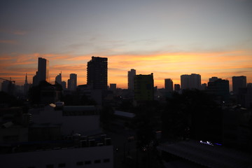 Fototapeta na wymiar Beautiful city sunset scene and tall buildings silhouette at the background of Saigon city, Vietnam.